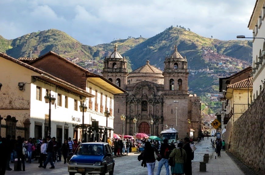 kerk in Cusco met bergen - Reizen met kinderen in Peru - Avontuurlijke Familiereis Peru